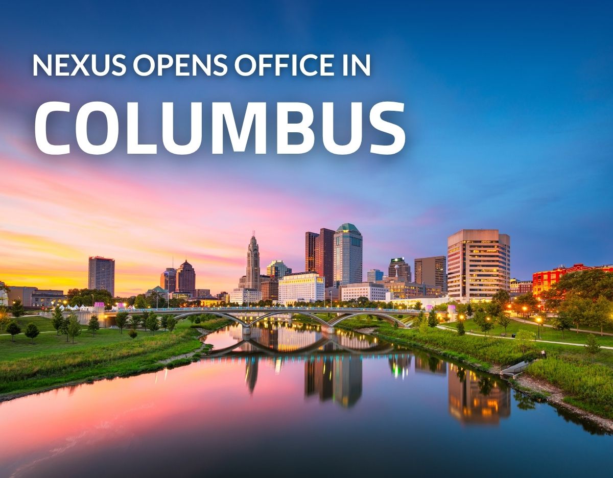 Promotional graphic announcing “NEXUS OPENS OFFICE IN COLUMBUS” over a vibrant sunset view of the Columbus, Ohio skyline. Downtown buildings, a bridge spanning the Scioto River, and colorful reflections on the water are visible beneath a blue, pink, and orange sky.